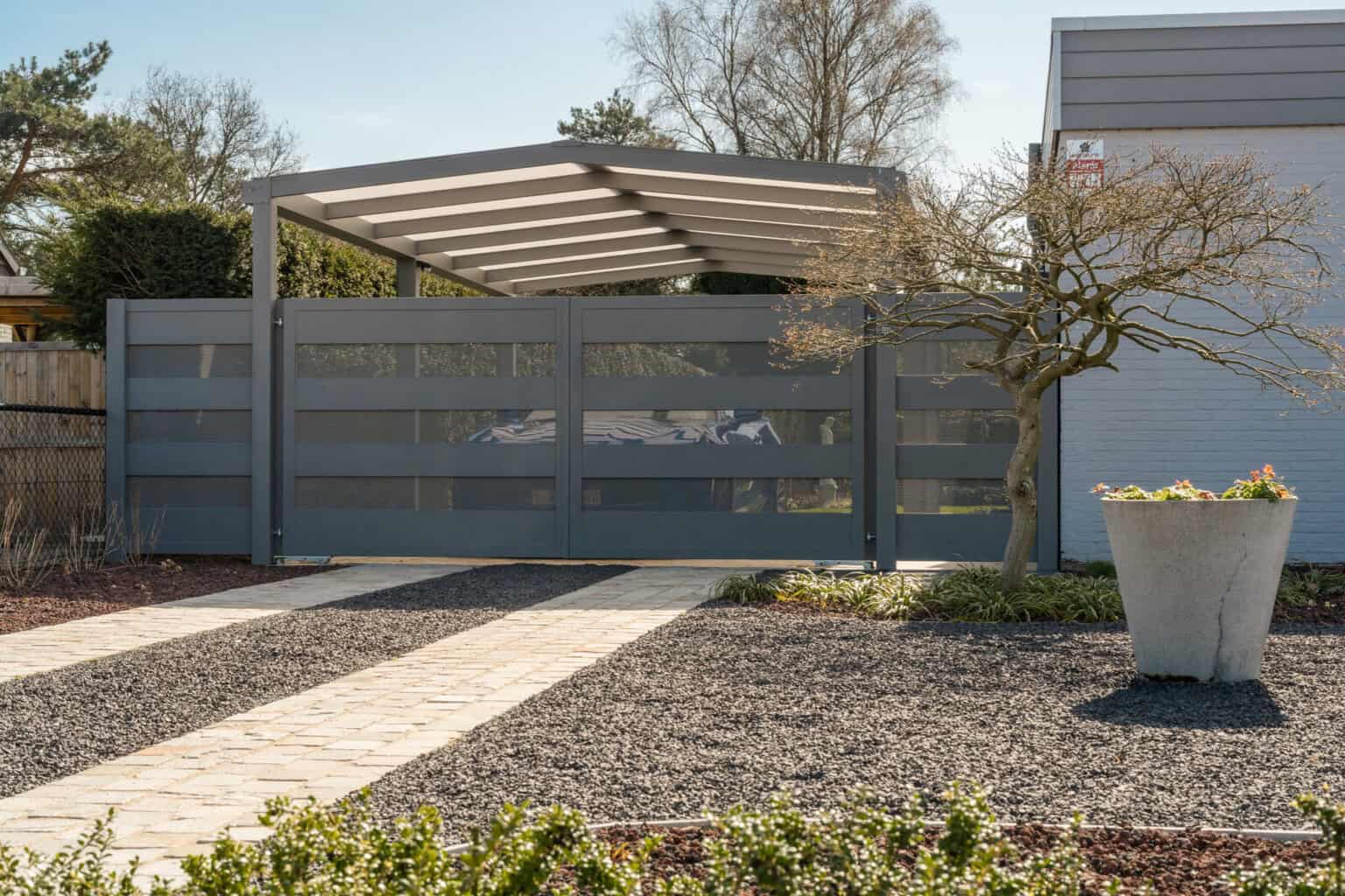 donkere metalen draaipoort aan een carport